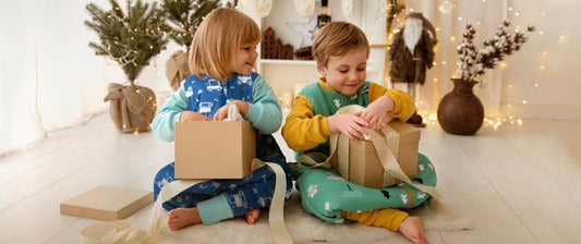 boy and girl in sleeping bags with feet opening christmas gifts