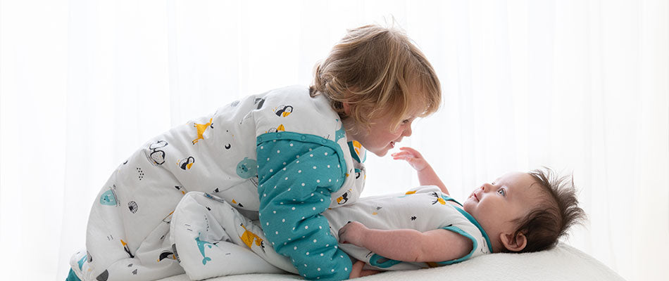 baby and toddler cuddling in winter sleeping bags