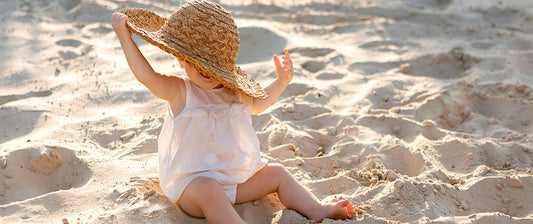 toddler on beach in big hat