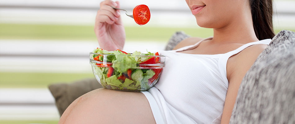 pregnant woman eating salad