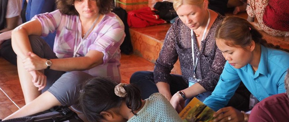 women in cambodia watching a cambodian lady work