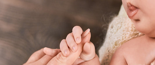 baby holding parents hand