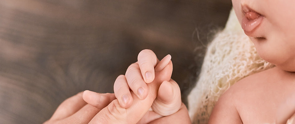 baby holding parents hand