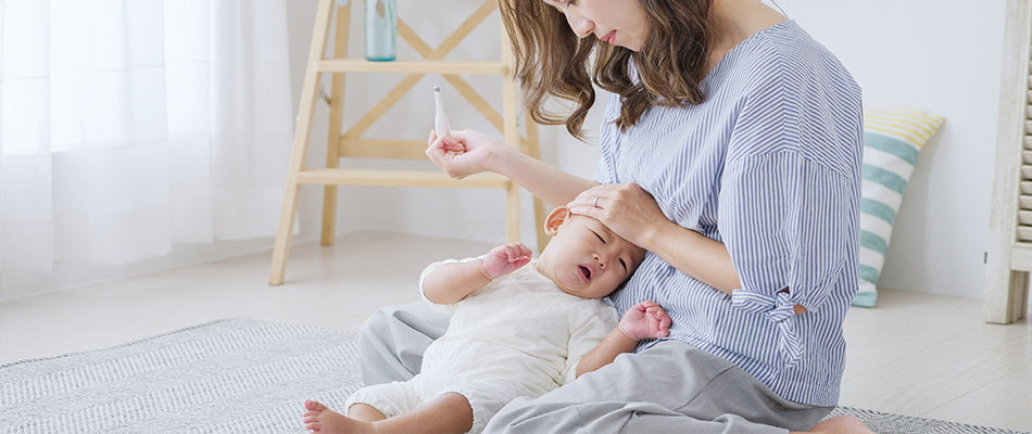 mum taking temperature of baby