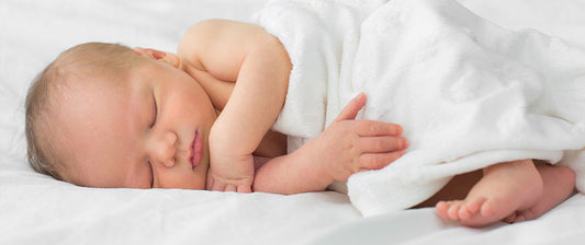 baby sleeping in muslin sheet