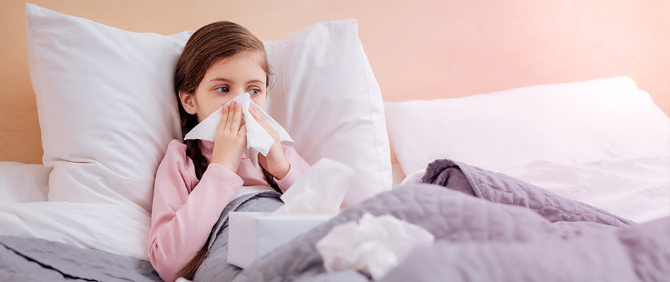 girl in bed blowing her nose