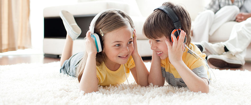 a boy and girl listening to music on headphones