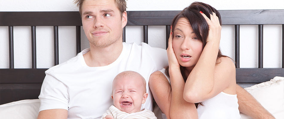 baby crying with mum and dad in bed