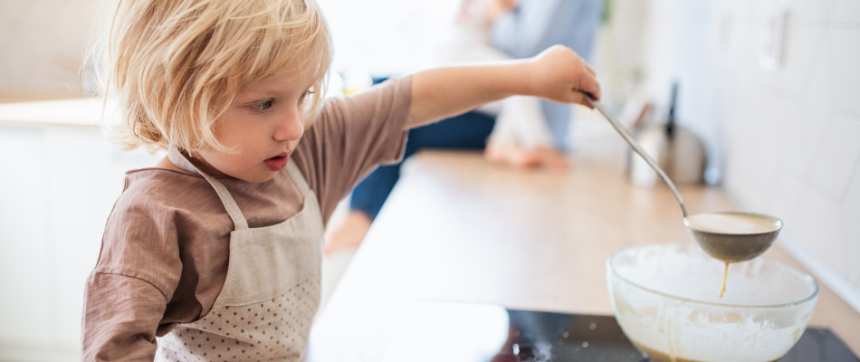 toddler in kitchen with pancake mix