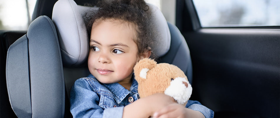 girl in car holding a teddy