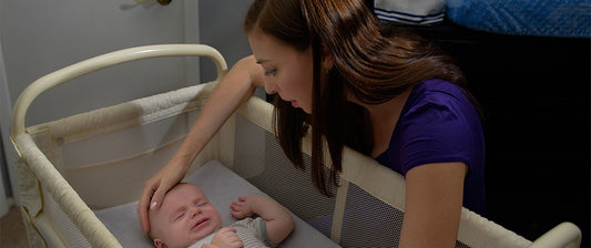 baby in crib with mum looking down